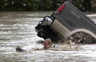 Kevan Yaets swims after his cat Momo to safety as the flood waters sweep him downstream and submerge his truck in High River, Alberta on Thursday, June 20, 2013 after the Highwood River overflowed its banks. Hundreds of people have been evacuated with volunteers and emergency crews helping to aid stranded residents. 