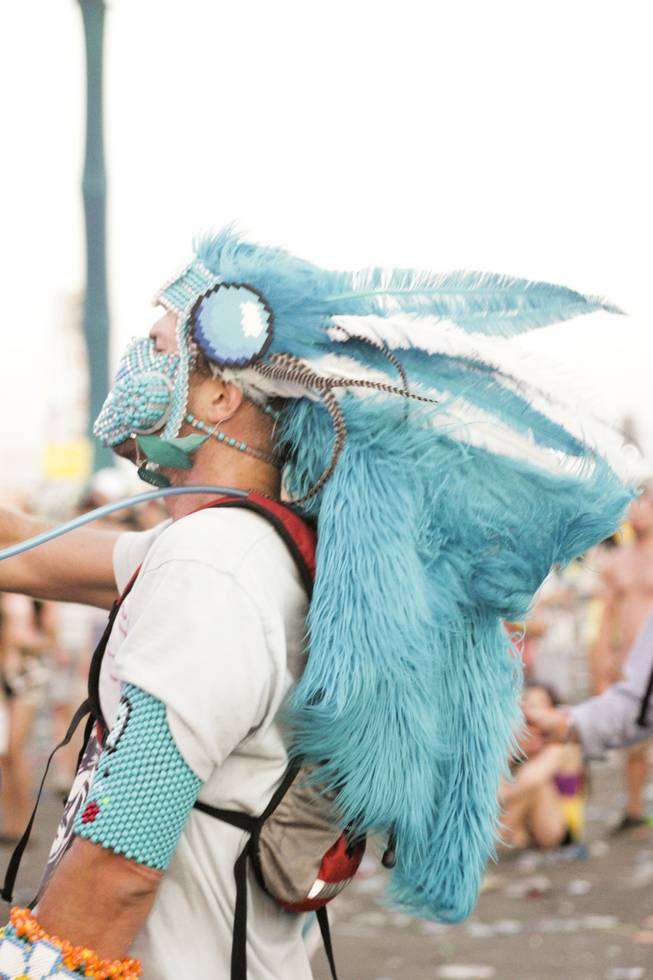 A festival goer wears a large blue feathered head dress at the Electric Daisy Carnival Festival, EDC, at the Las Vegas Motor Speedway, Sunday morning, June 23, 2013.