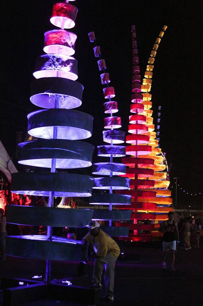 A man leans on one of the art installations at the Electric Daisy Carnival Festival, EDC, at the Las Vegas Motor Speedway, Sunday morning, June 23, 2013.