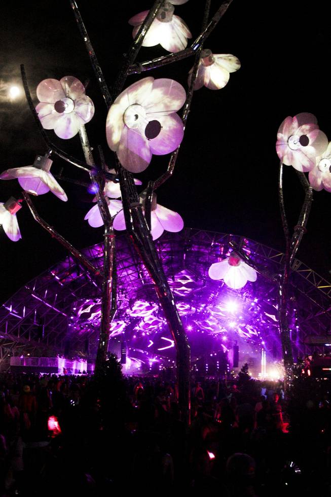 The full moon is seen behind an art installation at the Electric Daisy Carnival Festival, EDC, at the Las Vegas Motor Speedway, Sunday morning, June 23, 2013.