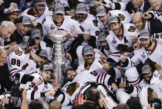 The Chicago Blackhawks pose with the Stanley Cup after beating the Boston Bruins 3-2 in Game 6 of the NHL hockey Stanley Cup Finals, Monday, June 24, 2013, in Boston. 