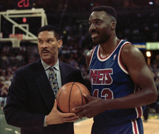 Armen Gilliam (right) accepts a commemorative ball from New Jersey Nets coach Butch Beard after Gilliam scored his 10,000th career NBA point on Feb. 21, 1996, in Milwaukee.