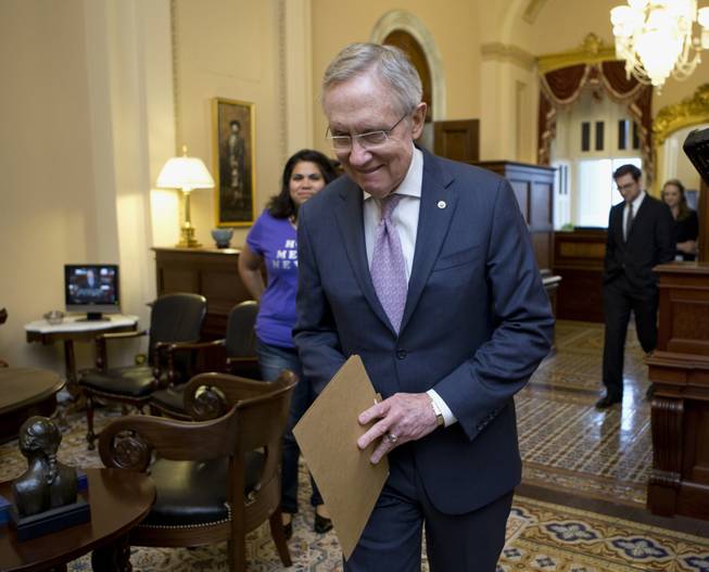 Senate Majority Leader Harry Reid of Nev. walks to the Senate floor on  Capitol Hill in Washington, Thursday, June 27, 2013, after meeting with Astrid Silva, of Las Vegas, rear left, a DREAM Act supporter whose family came to the U.S. from Mexico illegally and whose story has been an inspiration for Reid during work on the immigration reform bill. Reid carries a folder with letters from Astrid Silva that he read on the Senate floor before the historic vote.