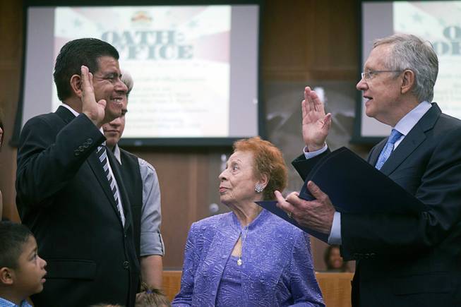 Councilman Isaac Barron, left, is sworn in by Senate Majority Leader Harry Reid (D-NV) during an oath of office ceremony at North Las Vegas City Hall Monday, July 1, 2013. Barron is the first Hispanic to serve on the North Las Vegas City Council. Barron's aunt Socorro Molina is at center.
