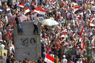 Opponents of Egypt's Islamist President Mohammed Morsi shout slogans during a protest in Tahrir Square in Cairo, Egypt, Wednesday, July 3, 2013. Arabic reads, 