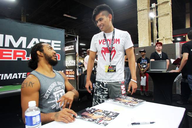 Jose Bernardo gets a chance to talk to UFC fighter Benson Henderson at the Ultimate Poker booth during the UFC Fan Fest at Mandalay Bay Friday, July 5, 2013.