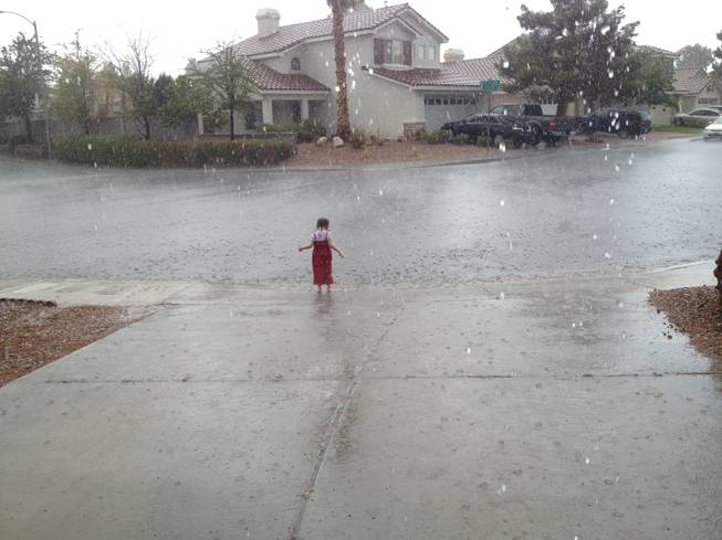 A girl plays in the rain in Green Valley, Sunday, July 7, 2013.