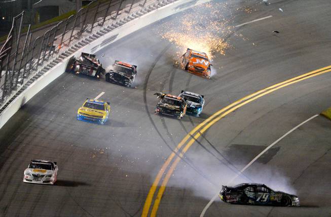 Jeffrey Earnhardt (79) spins on the apron after colliding in Turn 4 with Travis Pastrana, rear left, Robert Richardson Jr. (23), Jamie Dick (55), Kevin Swindell, middle right, and Jason White, rear right, during the NASCAR Nationwide auto race at Daytona International Speedway in Daytona Beach, Fla., Friday, July 5, 2013.