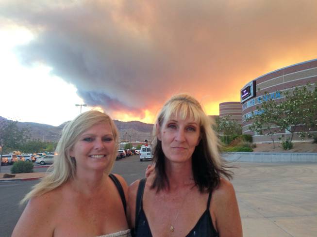 Kim Coster, right, and Kerri Paniagua were among the Mount Charleston evacuees who attended an informational meeting at Centennial High School on Monday night, July 8, 2013. Smoke from the vast wildfire turned a bright, fiery orange as the sun began to set behind the Spring Mountains. 