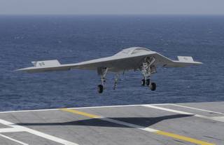 A X47-B Navy drone approaches the deck as it lands aboard the nuclear aircraft carrier USS George H. W. Bush off the Coast of Virginia Wednesday, July 10, 2013. 