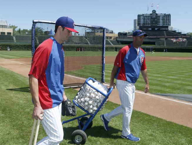 Chicago Cubs' first-round draft pick Kris Bryant, left, walks out to the field as he takes batting practice with manager Dale Sveum before a baseball game against the St. Louis Cardinals Friday, July 12 2013, in Chicago. 