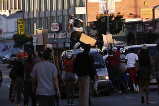 A protester stomps on a van during a demonstration in reaction to the acquittal of neighborhood watch volunteer George Zimmerman on Monday, July 15, 2013, in Los Angeles. Anger over the acquittal of a U.S. neighborhood watch volunteer who shot dead an unarmed black teenager continued Monday, with civil rights leaders saying mostly peaceful protests will continue this weekend with vigils in dozens of cities.
