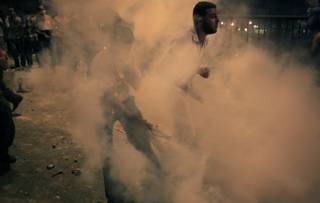 Supporters of ousted President Mohammed Morsi run from the tear gas during clashes in downtown Cairo, Egypt, Monday, July 15, 2013. 