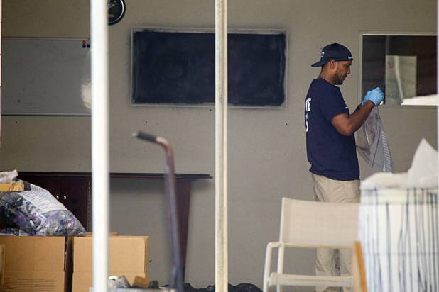 An investigator bags evidence during a Homeland Security raid at a warehouse space behind the Power Exchange sex club on Highland Drive Wednesday, July 17, 2013.