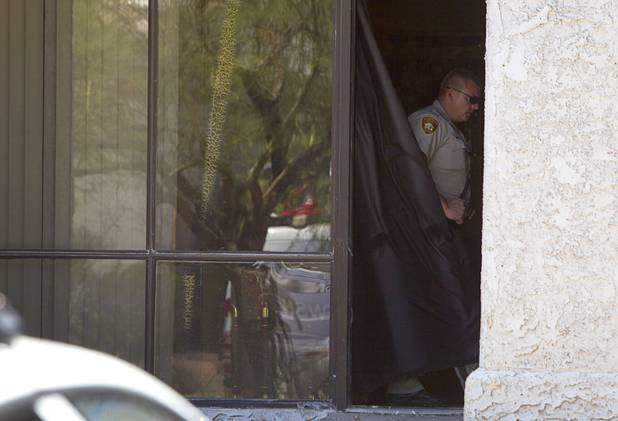 A Metro Police officer is shown in a doorway at the Power Exchange sex club on Highland Drive Wednesday, July 17, 2013. Homeland Security investigators raided a warehouse space behind the Power sex club.