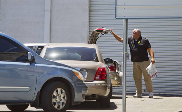 An investigator takes an evidence bag from his trunk during a Homeland Security raid at a warehouse space behind the Power Exchange sex club on Highland Drive Wednesday, July 17, 2013.