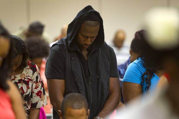Darnell Williams bows his head for an opening prayer during a town hall discussion at the Pearson Community Center in North Las Vegas Wednesday, July 17, 2013. The discussion, titled After Trayvon Martin: What Now?, attracted more than 200 people. The Phi Beta Sigma fraternity sponsored the event.