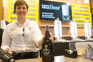 Melissa Long-Higgs, store manager for Total Wine & More on North Stephanie St., fills up a beer growler at their Brewery District inside their store, Wednesday July 17, 2013.