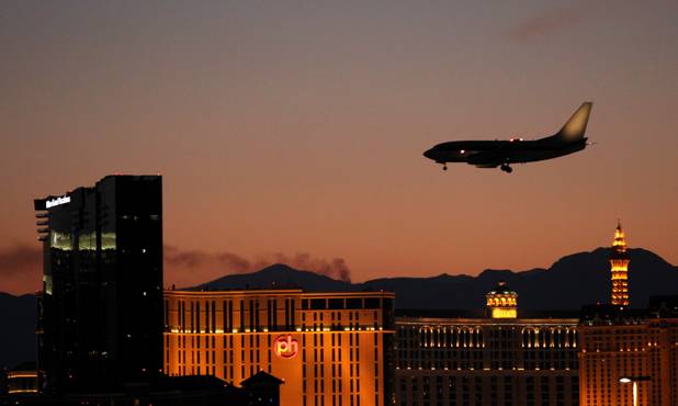 A plane comes in for a landing at McCarran International Airport as smoke from the fire on Mount Charleston streams south Wednesday, July 17, 2013.