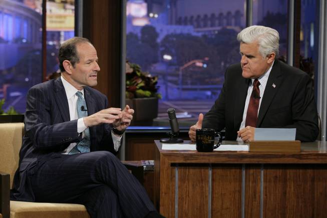 This publicity image released by NBC shows former New York Gov. Eliot Spitzer, left, talking with host Jay Leno during a taping of "The Tonight Show with Jay Leno," Friday, July 12, 2013, in Burbank, Calif. Spitzer, who resigned as governor in 2008 amid a prostitution scandal, is now running for New York City comptroller. 