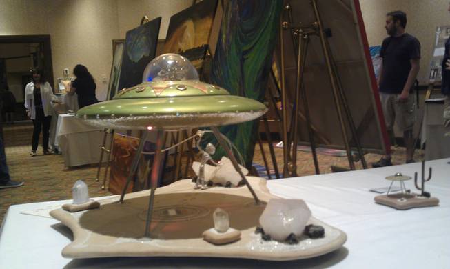 UFO art on display at the annual Mutual UFO Network Symposium at the JW Marriott Las Vegas Resort on Sunday morning. The green sculpture in the foreground, entitled "Power", was created by amauter artist Michael Harley, who said the work took several months to complete. Harley said the piece, which was priced at $600, came from his imagination and was created out of porcelain plates and LED lighting. The conference featured art from 10 different artists, each with a unique spin on alien-inspired artwork.