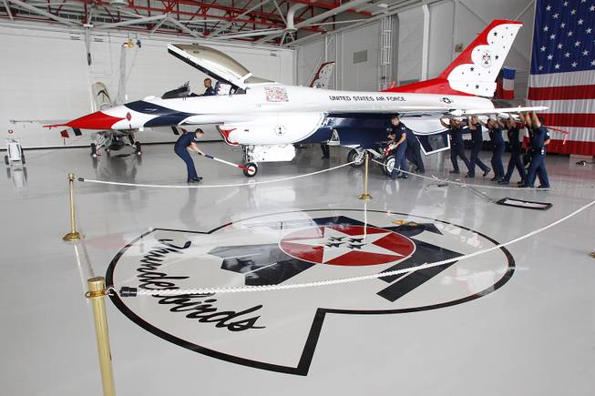 Crew members move an F-16 in the Thunderbird hangar as the Thunderbirds resume limited flight operations at Nellis Air Force Base Tuesday, July 22, 2013 after having to stand down since April because of sequestration.