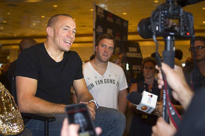 UFC welterweight champion Georges St. Pierre, left, of Canada talks with reporters during a UFC news conference in the lobby of the MGM Grand Monday, July 29, 2013. St. Pierre will defend his welterweight title against Johny Hendricks of Dallas, Texas during UFC 167 on Nov. 17 at the MGM Grand.