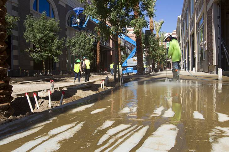 A worker pressure washes a sidewalk during a tour of Caesars Entertainment's Linq development Tuesday, July 29, 2013. The $550 million shopping, dining and entertainment district will be anchored by the 550-foot-tall High Roller observation wheel. The project's first phase is expected to open in late 2013.