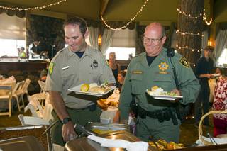 Nevada Division of Forestry firefighter Steve Clement and Metro Police resident officer Mark Baumann go through a buffet line during a free appreciation dinner for firefighters, law enforcement officers, Red Cross volunteers and Mount Charleston residents at the Resort on Mount Charleston Wednesday, July 31, 2013. The Resort on Mount Charleston hosted the dinner to thank everyone involved with fighting the Carpenter 1 wildfire.