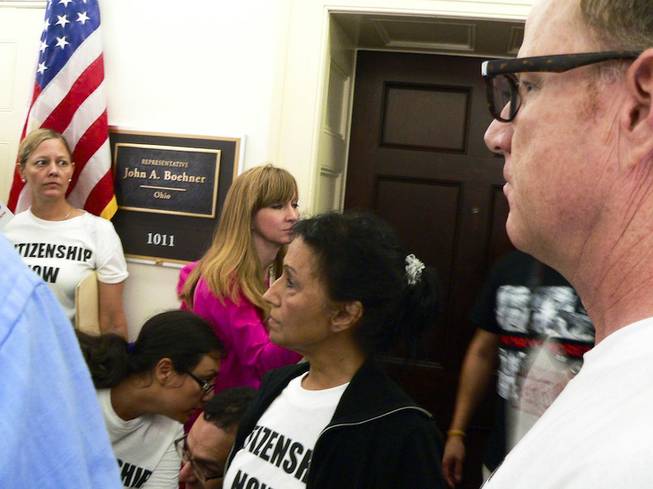 Theresa Navarro, center, and Bob Fulkerson, right, of PLAN stand outside House Speaker John Boehner's district office in the Longworth House Office Building in Washington, D.C., during an immigration demonstration Thursday, July 31, 2013.