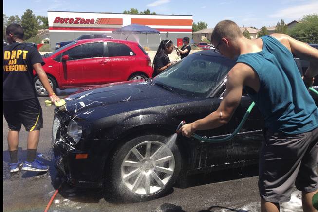Metro Explorers hold a car wash fundraiser Saturday, Aug. 3, 2013, at Brake Masters on South Eastern Avenue to help with funeral expenses for Angel Velasquez's family.