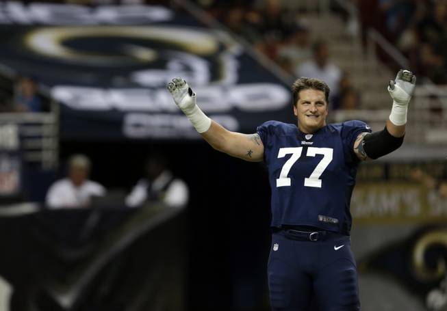 St. Louis Rams tackle Jake Long warms up for an NFL football training camp scrimmage inside the Edward Jones Dome, Saturday, Aug. 3, 2013, in St. Louis. (AP Photo/Jeff Roberson)