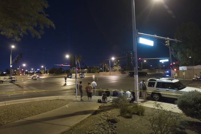 People involved in the accident wait as Metro Police investigate at Rainbow Boulevard and Twain Avenue on Saturday, Aug. 3, 2013. Several people were reported injured in the accident that involved five vehicles, including a limousine.