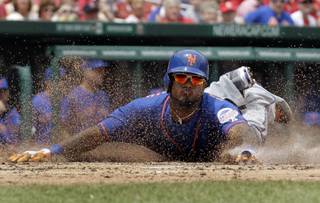 New York Mets' Jordany Valdespin slides head first into home plate to score on an RBI double by Daniel Murphy during the third inning of a baseball game against the St. Louis Cardinals Thursday, May 16, 2013, in St. Louis. 