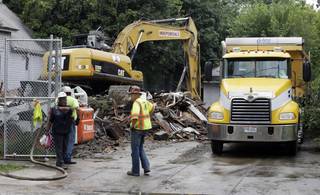 The house where three women were held captive and raped for more than a decade is demolished, Wednesday, Aug. 7, 2013, in Cleveland. Authorities want to make sure the rubble isn't sold online as 