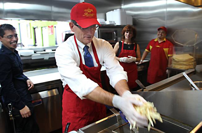 Rep. Joe Heck drops french fries into the deep fryer at Roberto's Taco Shop on Boulder Highway in Henderson on Monday, Aug. 12, 2013. Heck met with Reynaldo and Rogelio Robledo, two members of the chain's founding family, who discussed business and policy with the congressman.