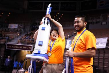 Ana Martinez of the Monte Carlo celebrates after winning the vacuum race during the Annual City Wide Housekeeping Olympics at the Mandalay Bay Events Center in Las Vegas on Wednesday, August 14, 2013.