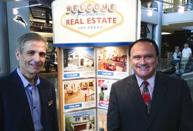 From left, 24/7 Real Estate brokers George Kleanthis and Tony Keep pose for a photo at their company's kiosk at Las Vegas' Fashion Show mall on Aug. 5, 2013. 