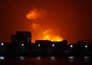 The night sky is lit up as a fire burns aboard INS Sindhurakshak, an Indian Navy kilo class submarine early Wednesday Aug. 14, 2013,  in Mumbai, India.  