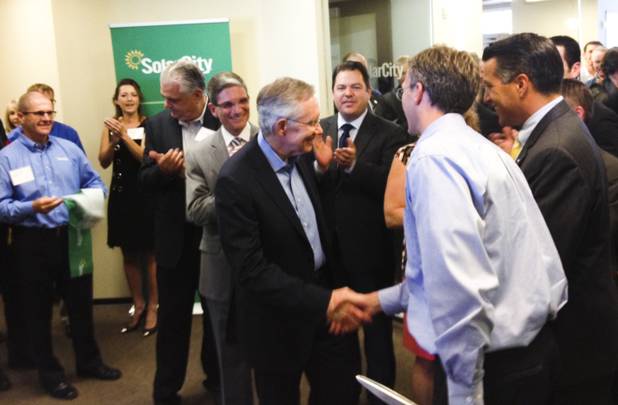 Clark County Commissioner Steve Sisolak, Rep. Joe Heck and Gov. Brian Sandoval, right, gather around Senate Majority Leader Harry Reid as he greets SolarCity CEO Lyndon Rive after cutting the ribbon to open the Las Vegas office of SolarCity at Town Square, Wednesday, Aug. 14, 2013.