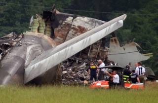 NTSB investigators work around the tail section of the UPS cargo plane that crashed on approach to the Birmingham-Shuttlesworth International Airport August 15,  2013 in Birmingham, Ala.  