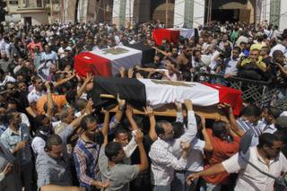 Egyptian relatives and colleagues of policemen who were killed during Wednesday's clashes carry coffins covered with national flags during a military funeral in Cairo, Egypt, Thursday, Aug. 15, 2013. Egyptian authorities on Thursday significantly raised the death toll from clashes the previous day between police and supporters of the ousted Islamist president, saying hundreds of people died and laying bare the extent of the violence that swept much of the country and prompted the government to declare a nationwide state of emergency and a nighttime curfew. (AP Photo/Amr Nabil)