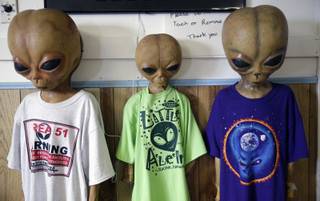 Alien dummies model t-shirts for sale along with other extraterrestrial-themed souvenirs at the Little A'Le'Inn, located nine miles up the road from the military testing base known as Area 51, in Rachel, Nev., Aug. 20, 2013. Last week, the CIA released a classified report officially confirming the existence of the military testing base famously rumored to have researched UFOs and alien life, though residents of the area have long known about it.