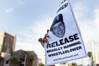 A protester holds up a flier in support of Army Pfc. Bradley Manning in front of the Lloyd George Federal Building in downtown Las Vegas Wednesday, Aug. 21, 2013. A military judge sentenced Manning to 35 years in prison for leaking hundreds of thousands of classified documents to WikiLeaks.