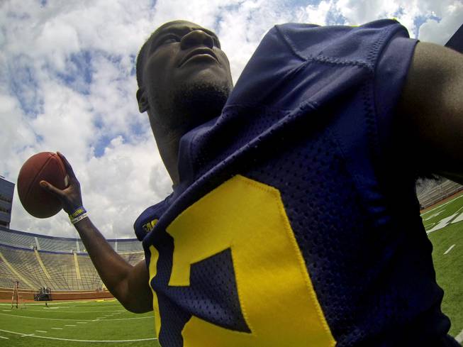 Michigan quarterback Devin Gardner captures a self-portrait from an arm-worn camera as he throws passes in Michigan Stadium during the NCAA college football team's annual preseason media day on Sunday, Aug. 11, 2013, in Ann Arbor, Mich.