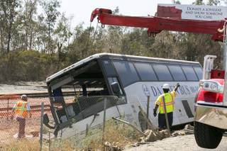 Salvage towing crews remove an overturned tour bus carrying gamblers to a casino on the 210 Southern California freeway injuring more than 50 people on board in Irwindale, Calif., on Thursday, Aug. 20, 2013. 