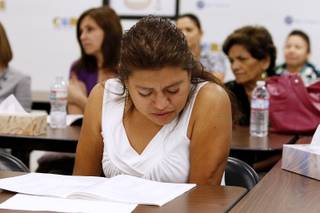 Maria Gomez follows along in a notebook while learning about the Bill of Rights during a citizen class at Congress of Racial Equality Saturday, Aug. 24, 2013.