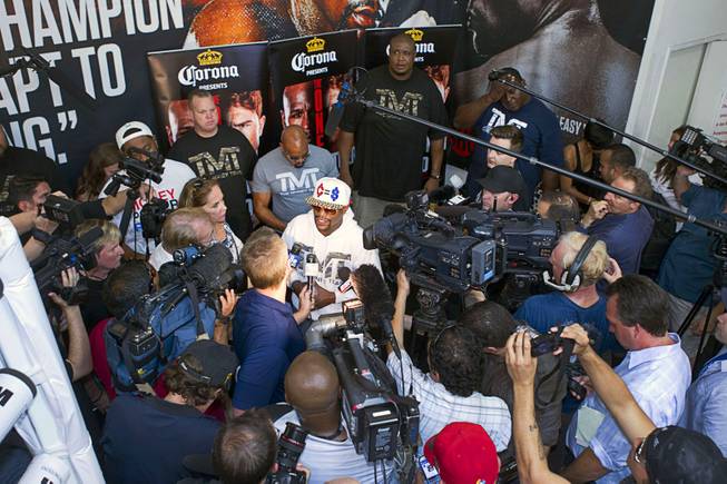 Undefeated boxer Floyd Mayweather Jr. (C) of the U.S. is surrounded by reporters and photographers at the Mayweather Boxing Club Wednesday, August 28, 2013. Mayweather will face Canelo Alvarez of Mexico in a WBC/WBA 154-pound title fight at the MGM Grand Garden Arena on September 14.