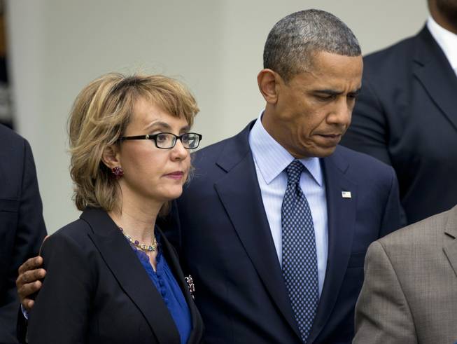 In this April 17, 2013, file photo, President Barack Obama puts his arm around former Arizona Rep. Gabrielle Giffords before speaking in the Rose Garden at the White House in Washington about measures to reduce gun violence. 
