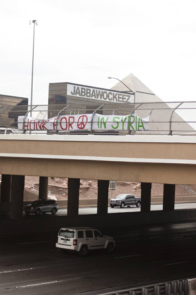 A "Honk For Peace In Syria" sign hangs from the Tropicana overpass at I-15 during a protest against U.S. intervention in Syria, Saturday, Aug. 31, 2013.
